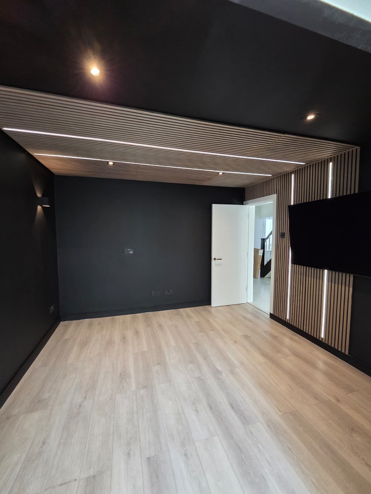 Entertainment room with slatted wood ceiling and LED lighting
