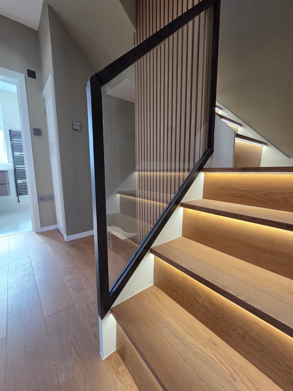 LED-lit oak staircase with glass balustrade